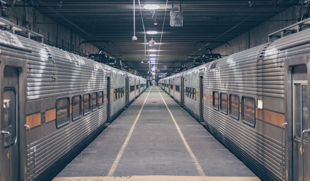 photo of two grey trains in station