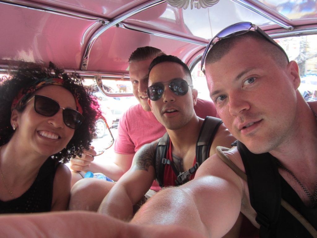 Friends riding a cramped tuk tuk in bangkok Thailand