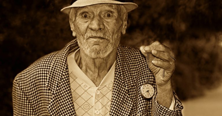 old man holding stop watch