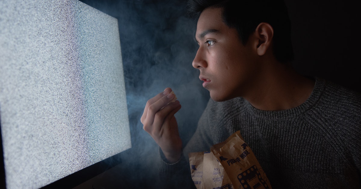 man eating chips while watching tv