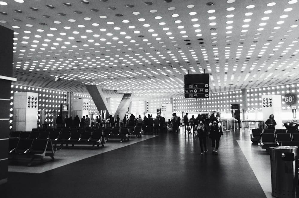 black and white airport with people lining up