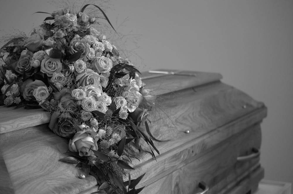 black and white casket with flowers on top